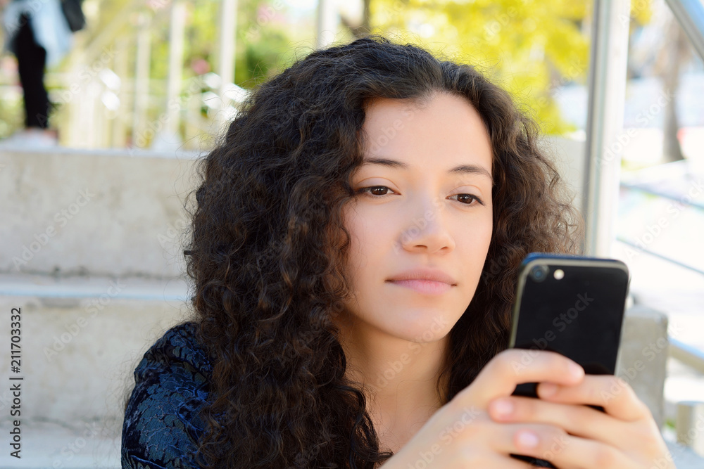 Young latin women sending message with smartphone.