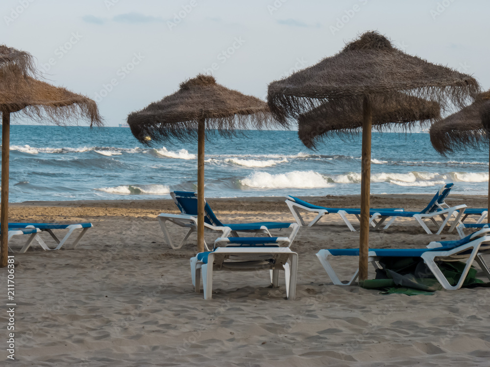 Beach straw umbrella and sun loungers