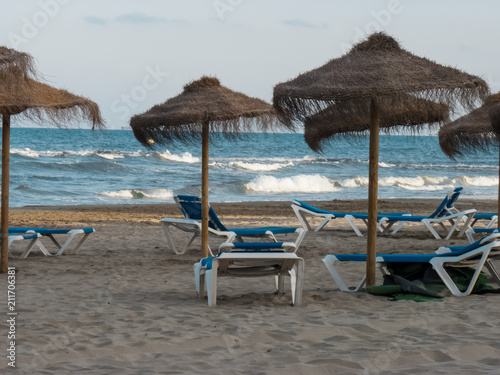 Beach straw umbrella and sun loungers