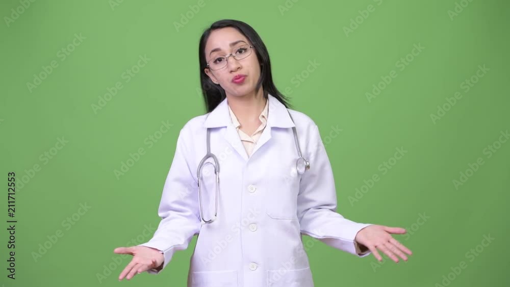 Young beautiful Asian woman doctor shrugging shoulders Young beautiful Asian woman doctor shrugging shoulders