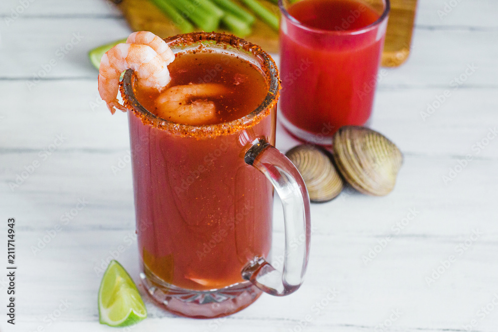 Michelada beer with tomato juice, shrimps, clam and lemon, mexican drink cocktail in mexico Michelada beer with tomato juice, shrimps, clam and lemon, mexican drink cocktail in mexico