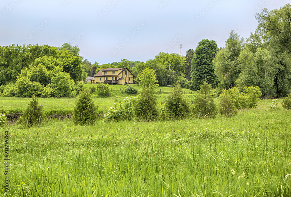 Farm house on the meadow on summer season in Ontario, Canada Farm house on the meadow on summer season in Ontario, Canada