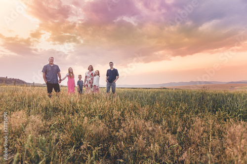 Family walking in a field in a sunset quality family time