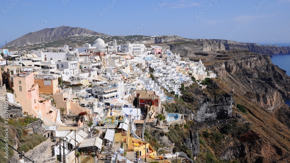 Famous stunning view of white architectures and colorful houses above the volcanic caldera in the village of Thira in Santorini island, Greece