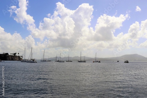 Sailboats on the ocean with a beautiful blue sky and puffy white cloud background