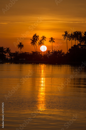 Beautiful sunset on the beach and coconut palm tree silhouette in island Koh Chang, Thailand