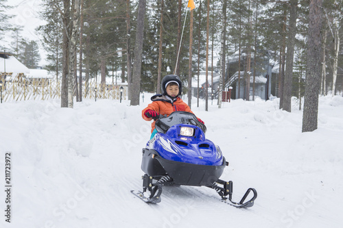 スノーモービルに乗る子供 雪景色