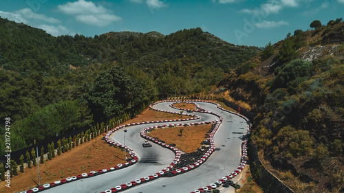 Aerial drone view of a kart racing in the forest with mountains on the background, Turkey
