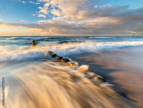 Fototapeta Naklejka Na Ścianę i Meble -  sunset over the sea beach in Poland, waves dynamically breaking into the beach