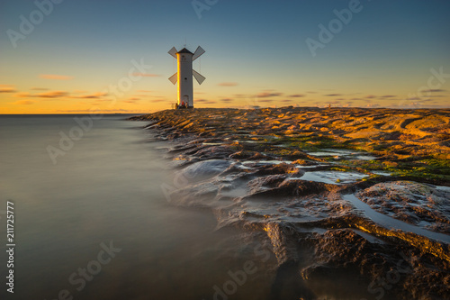 Lighthouse windmill  sunset over the sea Baltic Sea  Swinoujscie  Poland