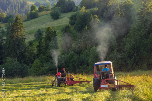 haymaking in the mountains, tractors with mowers cutting the meadows in the Polish mountains