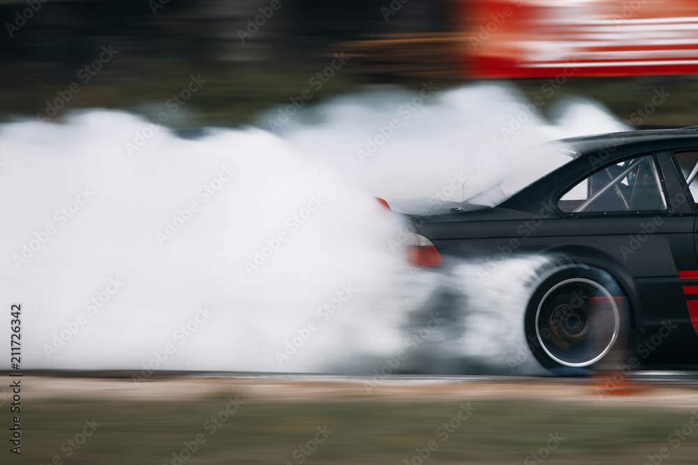 Sport car wheel drifting. Blurred of image diffusion race drift car with lots of smoke from burning tires on speed track. Race car go fast at raceway with a slide and a lot of smoke