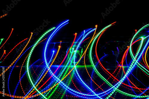 Blur colourful Abstract background of glowing stripes of streaks of light bands in a form of several lines on black background. Long exposure
