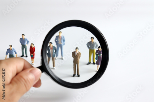 Magnifier and miniature people. Concepts for employment and recruitment.