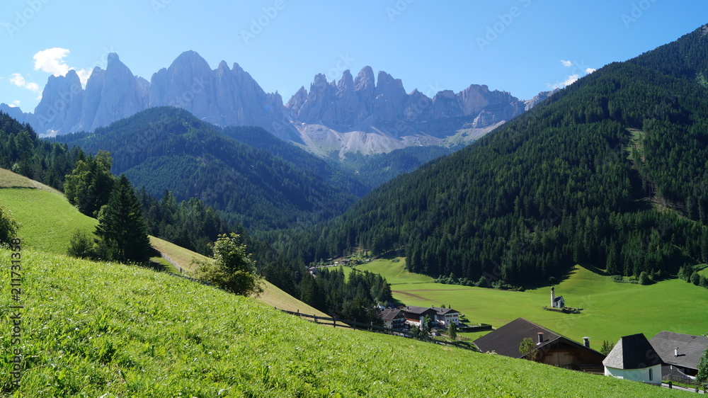 A panoramic view of a small village in the Italian Alps on the background of the Dolomites