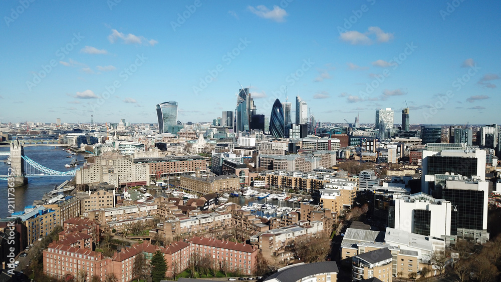 Aerial drone bird's eye view of iconic skyline in City of London as seen from St Katharine Docks Marina, London, United Kingdom