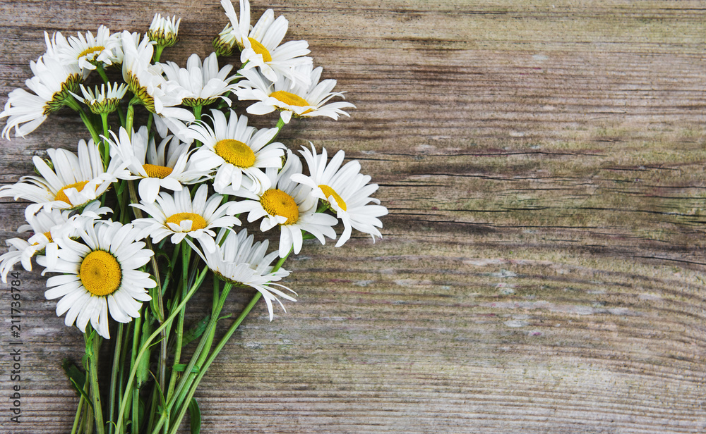Obraz premium Chamomile flowers on a wooden table