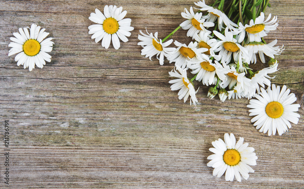 Obraz premium Chamomile flowers on a wooden table