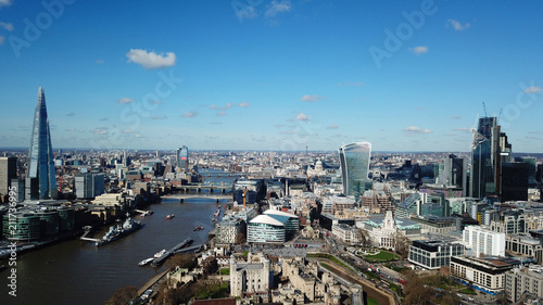 Aerial drone bird's eye view of iconic skyline in City of London as seen from St Katharine Docks Marina, London, United Kingdom