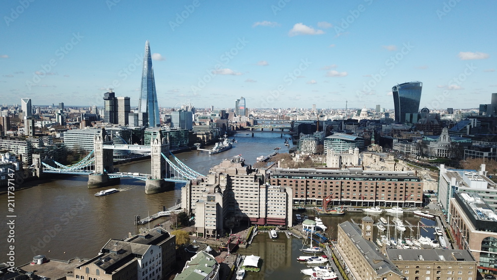 Aerial drone bird's eye view of iconic skyline in City of London as seen from St Katharine Docks Marina, London, United Kingdom