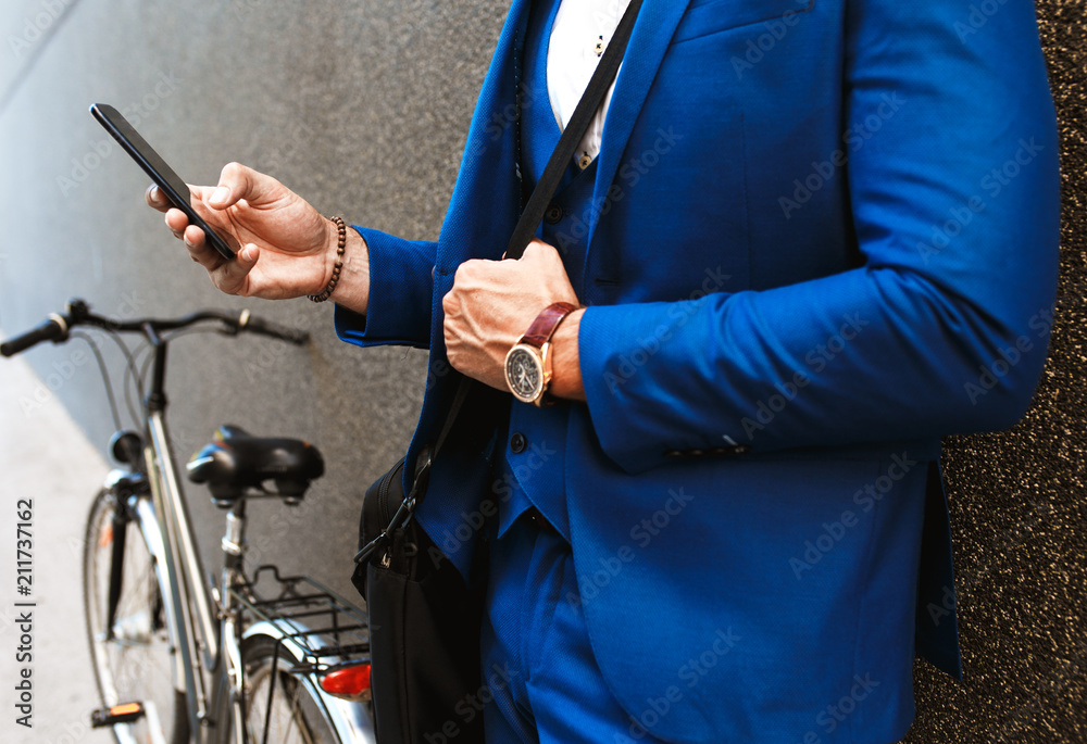 Close up of businessman hand holding phone and texting.