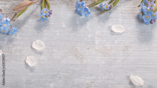 Festive wild spring summer small flowers forget-me-not composition on the blue wooden background. Overhead top view, flat lay. Copy space. Birthday, Mother's, Valentines, Women's, Wedding Day concept.