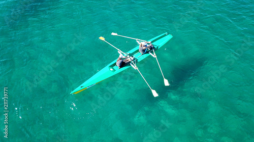 Aerial drone bird's eye view of kayak cruising in tropical seascape with turquoise and sapphire clear waters