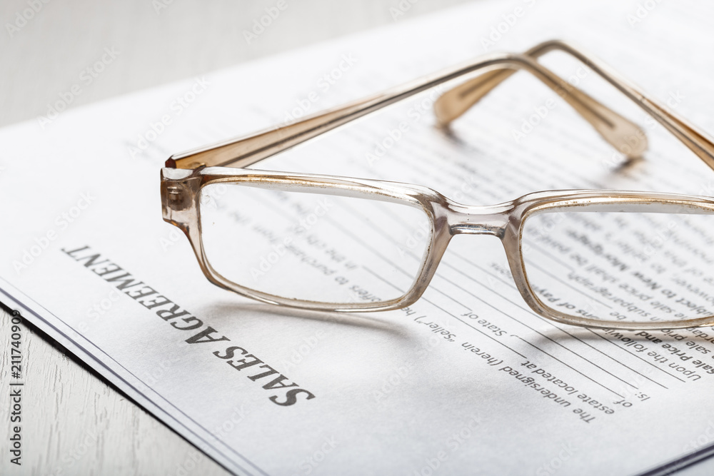 Close up shot of Eyeglasses on contract document papers business concept Close up shot of Eyeglasses on contract document papers business concept