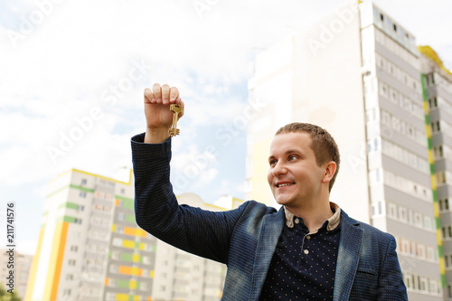 Happy man with keys to new home. Guy holding house key