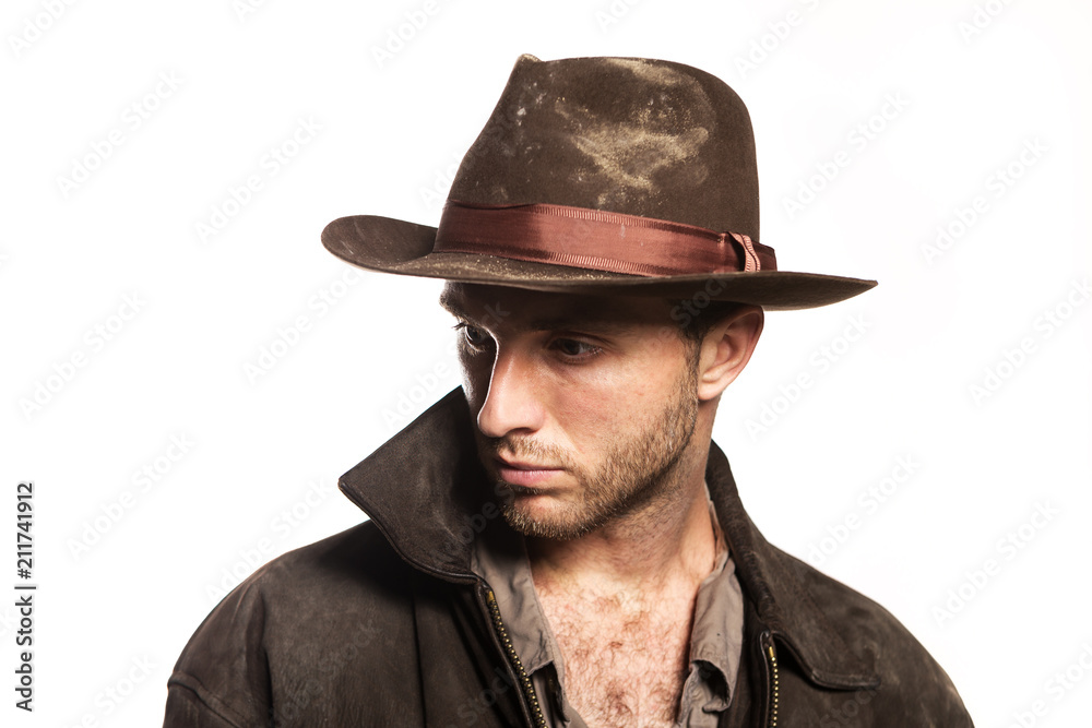 Young sexy unshaven man in cowboy hat. Indiana Jones image. Stylish dark  brown clothes on a white background Stock Photo | Adobe Stock