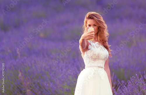 Happy bride take a selfie with her phone in lavender field