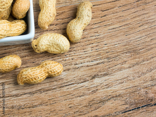 Unpeeled peanuts on white container