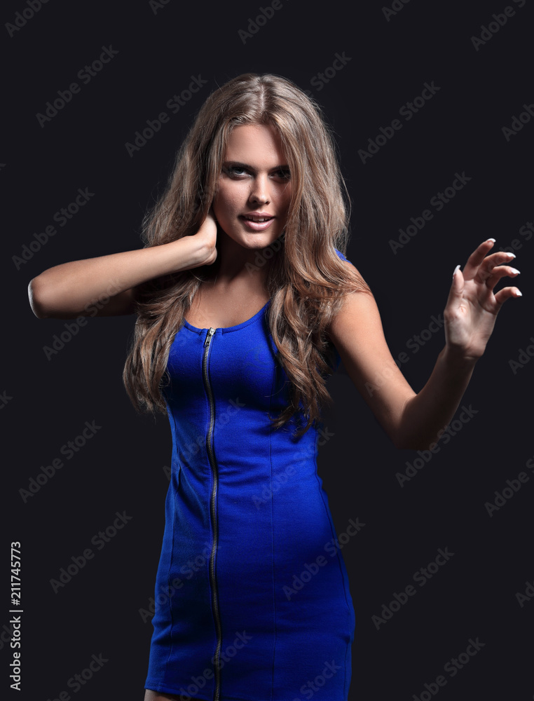 Beautiful woman in a blue dress posing on a black background Beautiful woman in a blue dress posing on a black background