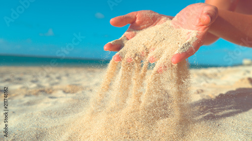 CLOSE UP: Unrecognizable woman lets breeze sweep away the sand from her hands.