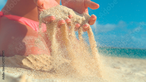 Fototapeta Naklejka Na Ścianę i Meble -  CLOSE UP: Unrecognizable woman in bikini picks up a handful of hot white sand.