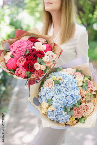 Two Beautiful summer bouquet. Arrangement with mix flowers. Young girl holding a flower arrangement with hydrangea. The concept of a flower shop. Content for the catalog