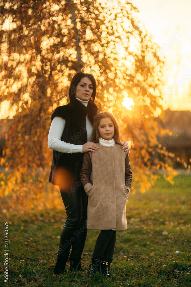 Little girl with mother walking in the park in autumn. Golden autumn Little girl with mother walking in the park in autumn. Golden autumn