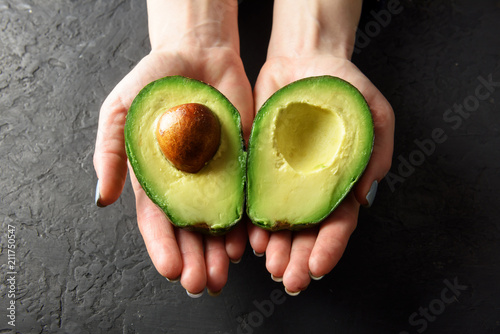 Fresh avocado fruit in girl hands. The concept of healthy eating. Food photography