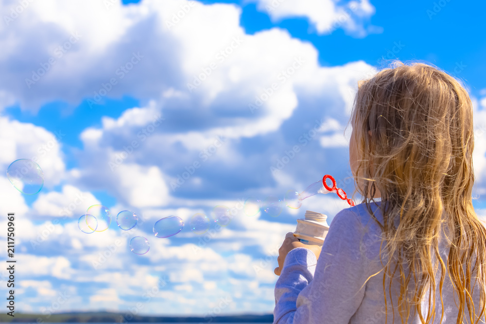 Girl having fun blowing soap bubbles. Photo from Sotkamo, Finland.