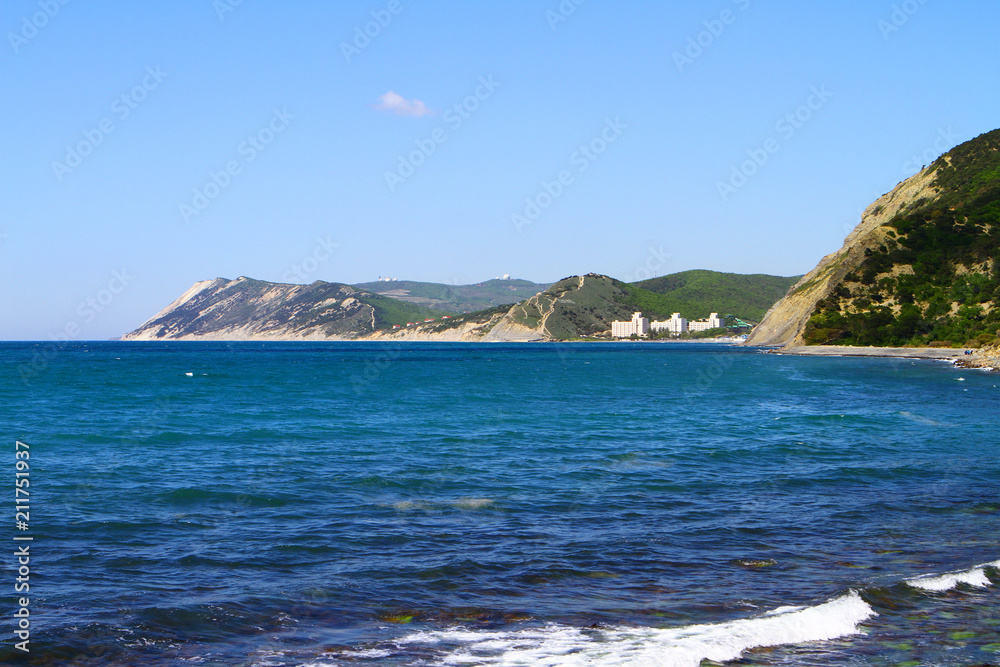 Black sea shore in Crimea - blue waves on the beach, mountains at summer time
