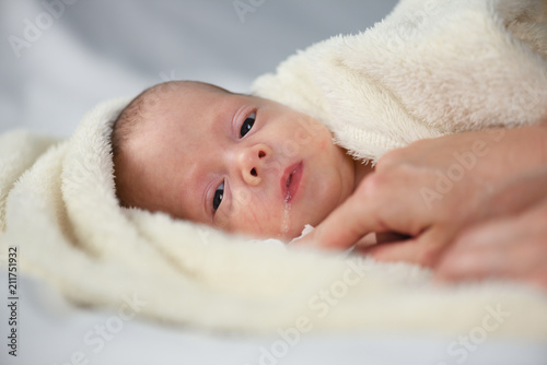 Newborn baby boy portrait on white carpet closeup. Motherhood and new life concept