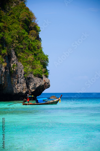 Cliff of Phi Phi island and wooden long tail boat in turquoise Andaman sea Krabi - Phuket, Thailand
