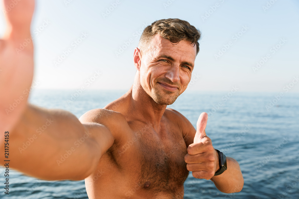 Smiling handsome shirtless sportsman taking a selfie Smiling handsome shirtless sportsman taking a selfie