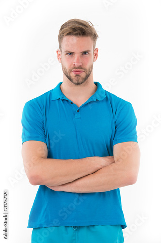 Man with trendy hairstyle and small bristle isolated on white background. Sportsman in blue outfit on training, health and fitness concept. Athlete with sexy muscular body folding arms at his chest