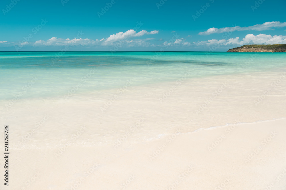 Clouds blue sky over calm sea beach tropical island. Tropical paradise beach with sand. Travel experts reveal Antigua best beaches. Sand pearlescent white claim as fine as powder. Paradise island