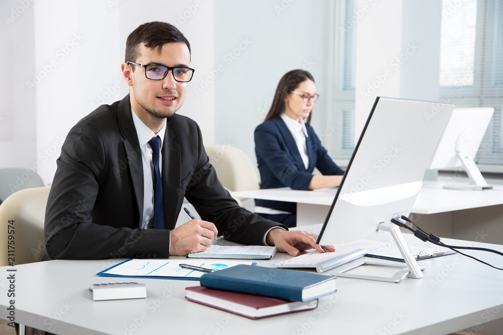 Young businessman working with computer in an office Young businessman working with computer in an office