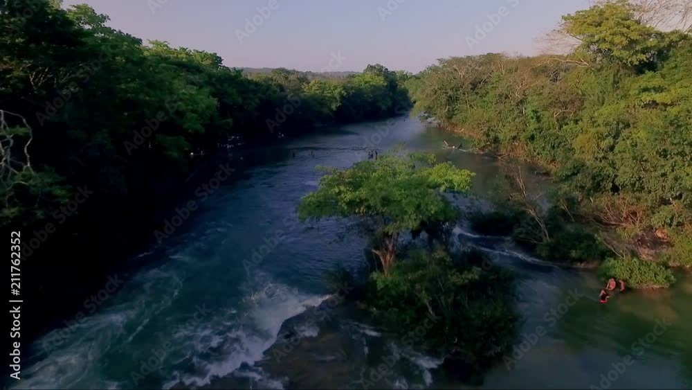 Smooth and beautiful shot of the Mopan River in Belize C.A. Very fluid shot of the beautiful waters with some people swimming in the refreshing water. Smooth and beautiful shot of the Mopan River in Belize C.A. Very fluid shot of the beautiful waters with some people swimming in the refreshing water.