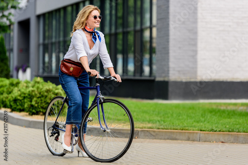 beautiful attractive woman sitting on bike on street