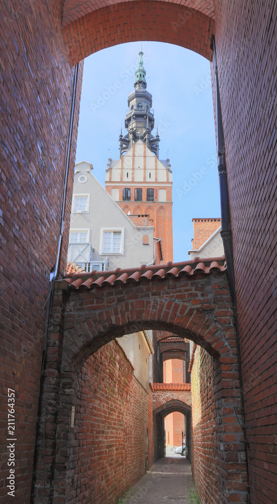 Obraz premium Church Path ( Ścieżka Kościelna) in Elblag. View of tower of St. Nicholas Church