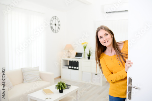 cheerful young woman welcome friends at open front door new student home apartment